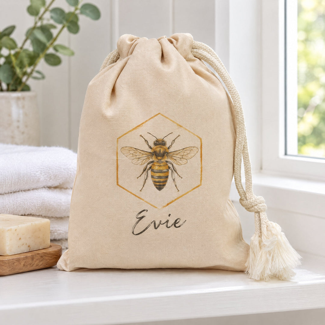 Natural cotton drawstring pouch 15 x 20cm printed with a vintage-illustration honey bee, on a bathroom shelf