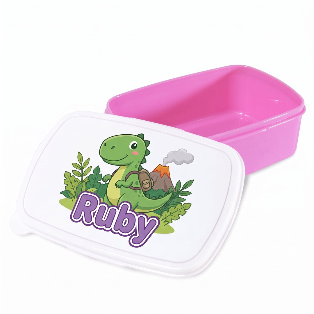 Pink plastic lunch box printed with a green dinosaur with a volcano and leaves design and the name Ruby
