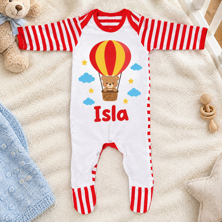 Sublimation baby grow printed with a cartoon teddy bear design and the name Isla, in a hot-air balloon basket