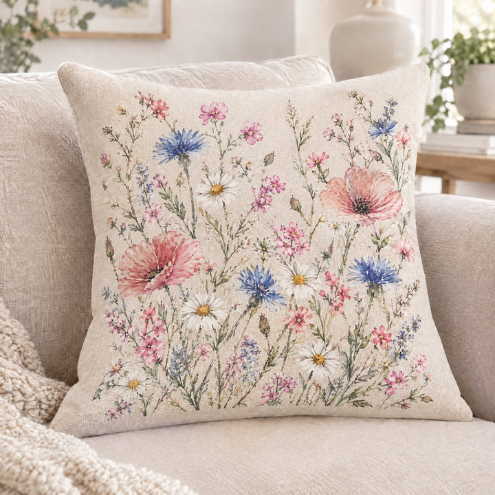 Sublimation linen cushion cover printed with a watercolour meadow of poppies, cornflowers and daisies, on a cream sofa