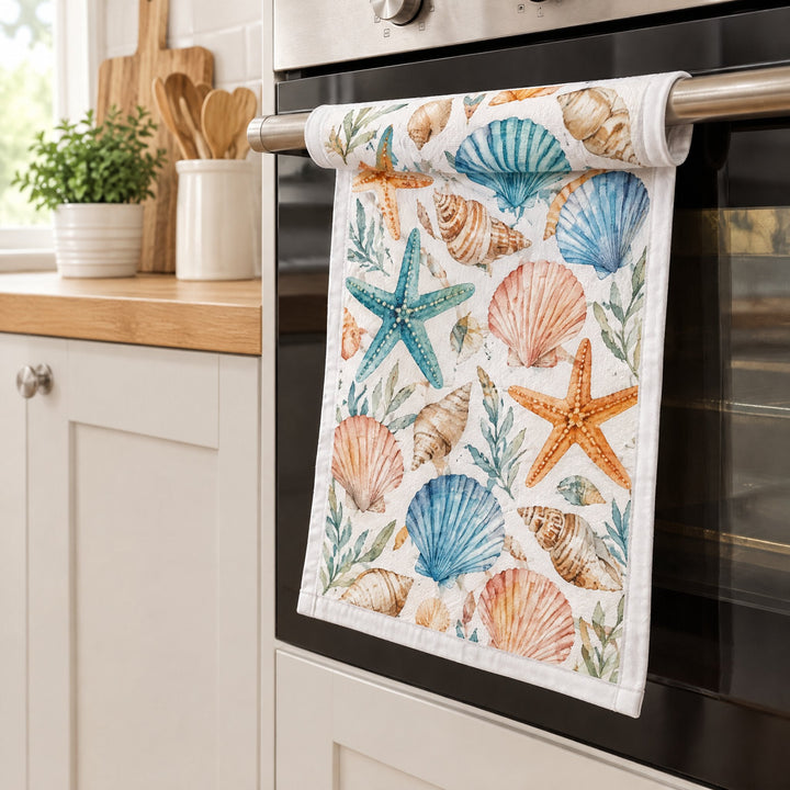 Sublimation tea towels, small, printed with seashells and starfish, hanging from an oven door
