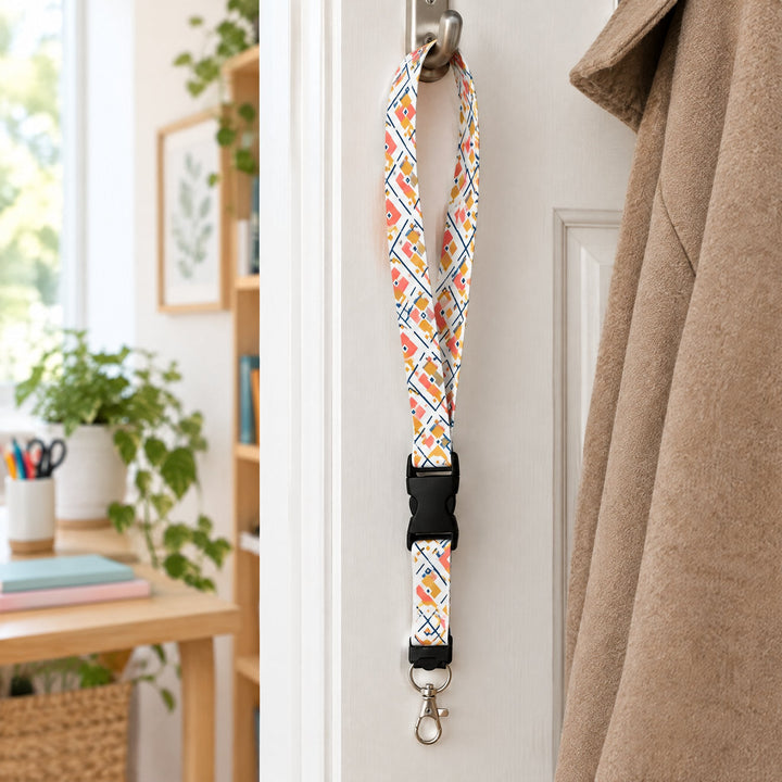 White sublimation lanyards printed with geometric diamonds, hanging from a door hook beside a coat